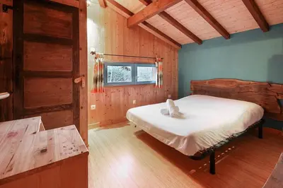 a bedroom with a bed in a room with wooden walls at Chalet of the 5 Chardons ski-in ski-out in Les Houches