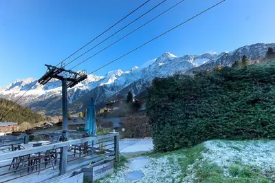a ski lift with tables and mountains in the background at Chalet of the 5 Chardons ski-in ski-out in Les Houches