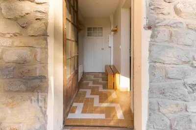 a hallway with a stone wall and a wooden bench at Le Petit Eloi in Saint-Gervais-les-Bains