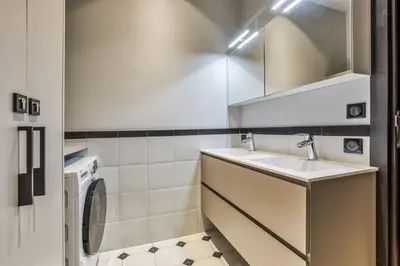 a bathroom with a sink and a washing machine at Majestic Broadway - 4 star apartment with spectacular views in Chamonix-Mont-Blanc