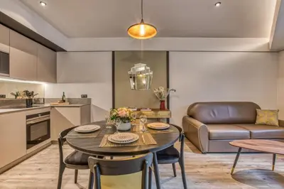a kitchen and living room with a table and a couch at Majestic Broadway - 4 star apartment with spectacular views in Chamonix-Mont-Blanc