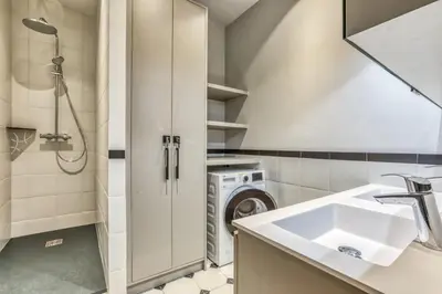a bathroom with a sink and a washing machine at Majestic Broadway - 4 star apartment with spectacular views in Chamonix-Mont-Blanc