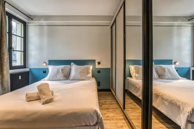 two beds in a room with mirrors at Majestic Broadway - 4 star apartment with spectacular views in Chamonix-Mont-Blanc