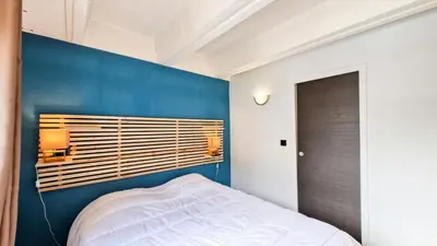 a bedroom with a blue accent wall and a bed at Résidence Betelgeuse - Appartement confortable · Proche des pistes et des commerces · Balcon MAE-7376 in Flaine