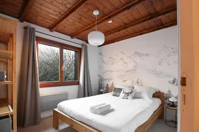 a bedroom with a large white bed and a window at Les Fleurs de Cham - Jardin vues - Rénové in Chamonix-Mont-Blanc