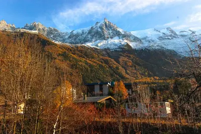 a house in front of a snow covered mountain at Les Fleurs de Cham - Jardin vues - Rénové in Chamonix-Mont-Blanc