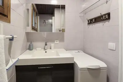 a white bathroom with a sink and a mirror at Les Fleurs de Cham - Jardin vues - Rénové in Chamonix-Mont-Blanc