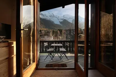 an open door with a view of a mountain at Les Fleurs de Cham - Jardin vues - Rénové in Chamonix-Mont-Blanc
