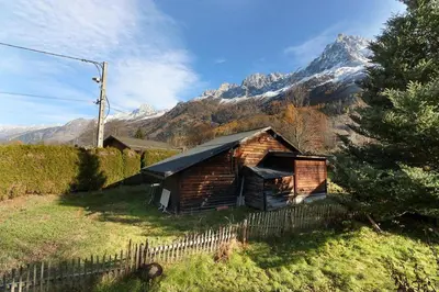 an old log cabin with a mountain in the background at Le Petite Chalet Tourmente in Chamonix-Mont-Blanc