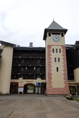 a clock tower in front of a large building at Vacancéole - Résidence Grand Morillon in Morillon
