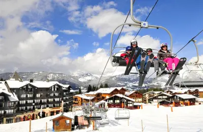a group of people riding a ski lift in the snow at Vacancéole - Résidence Grand Morillon in Morillon
