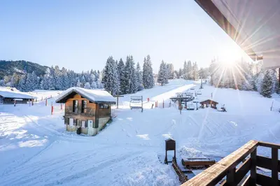 a ski lodge in the snow with the sun shining at Vacancéole - Résidence Grand Morillon in Morillon