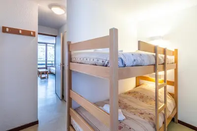 two bunk beds in a room with a hallway at Vacancéole - Résidence Grand Morillon in Morillon