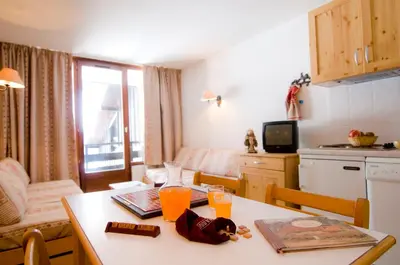 a kitchen and living room with a table with drinks on it at Vacancéole - Résidence Grand Morillon in Morillon
