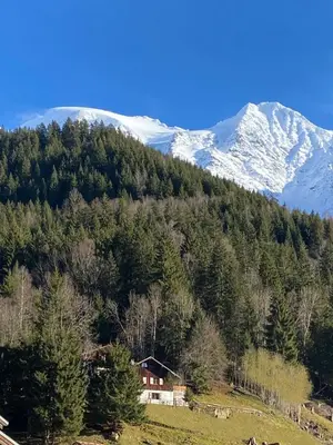 a house on a hill with a snow covered mountain at Chalet Keller in Les Contamines-Montjoie