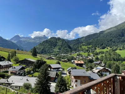a village in a valley with mountains in the background at Chalet Keller in Les Contamines-Montjoie