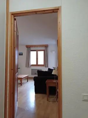 a living room with a couch and a table at Bel Appartement en résidence avec piscines in Samoëns