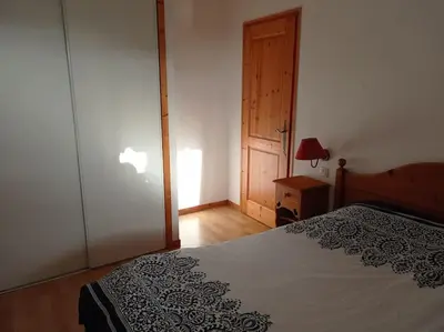 a bedroom with a bed and a door with a lamp at Bel Appartement en résidence avec piscines in Samoëns