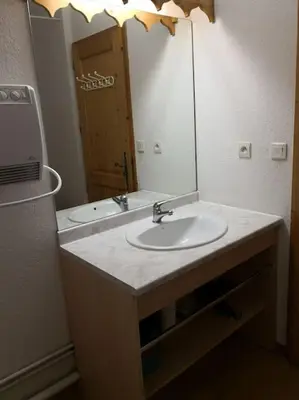 a bathroom with a sink and a mirror at Bel Appartement en résidence avec piscines in Samoëns