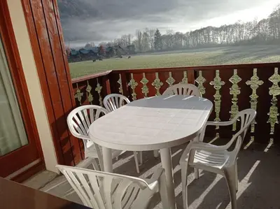 a white table and chairs on a balcony at Bel Appartement en résidence avec piscines in Samoëns