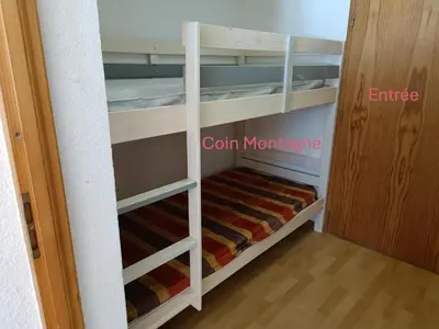 a small closet with white shelves and a wooden floor at Bel Appartement en résidence avec piscines in Samoëns