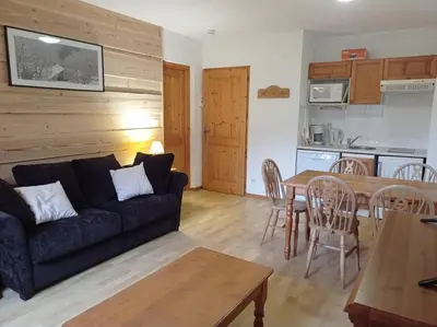 a living room with a couch and a table at Bel Appartement en résidence avec piscines in Samoëns