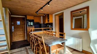 a kitchen and dining room with a table and chairs at Appartement Premium à Flaine, altitude 1740 m, 8 à 10 personnes, au pied des pistes, piscine, jacuzzi, sauna, hammam et salle de sport in Flaine