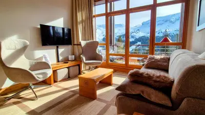 a living room with a couch and chairs and a large window at Appartement Premium à Flaine, altitude 1740 m, 8 à 10 personnes, au pied des pistes, piscine, jacuzzi, sauna, hammam et salle de sport in Flaine