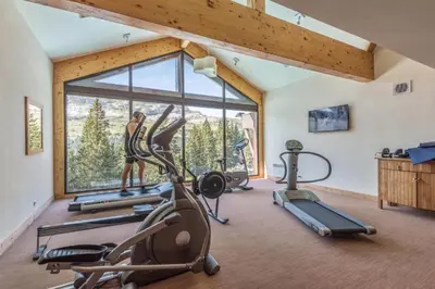 a gym with cardio equipment and a large window at Appartement Premium à Flaine, altitude 1740 m, 8 à 10 personnes, au pied des pistes, piscine, jacuzzi, sauna, hammam et salle de sport in Flaine