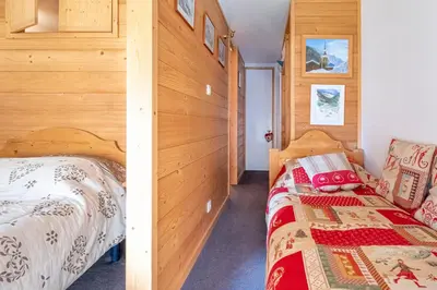 a bedroom with two beds and a wooden wall at Bel Apt Near The Slopes Argentiere in Chamonix-Mont-Blanc