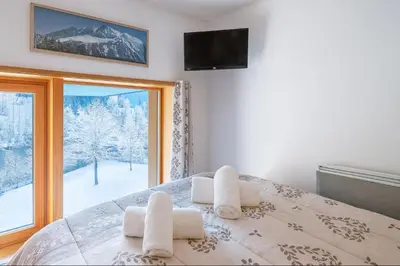 a bedroom with a bed and a window with a view at Bel Apt Near The Slopes Argentiere in Chamonix-Mont-Blanc