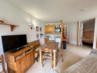 a living room with a table with a television and a kitchen at Appartement spacieux 6 pers. proche jardin d'enfants - FR-1-642-58 in Morillon