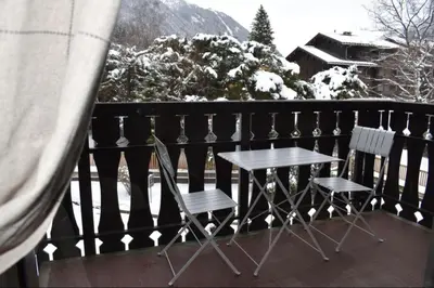 a table and two chairs on a balcony with snow at Studio Le 4122 - Chamonix centre Clos du Savoy in Chamonix-Mont-Blanc