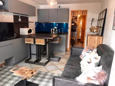 a living room with a couch and a kitchen at Studio Le 4122 - Chamonix centre Clos du Savoy in Chamonix-Mont-Blanc