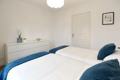 two beds in a white bedroom with blue pillows at Appartement L'Armancette - Proche centre et Bettex in Saint-Gervais-les-Bains