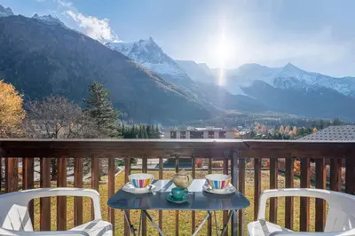a table on a balcony with a view of mountains at Nice Studio With Balcony In Chamonix in Chamonix-Mont-Blanc
