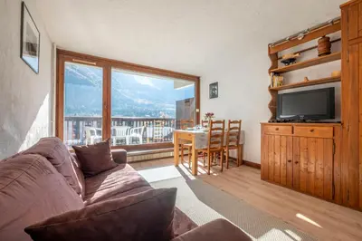 a living room with a couch and a television at Nice Studio With Balcony In Chamonix in Chamonix-Mont-Blanc