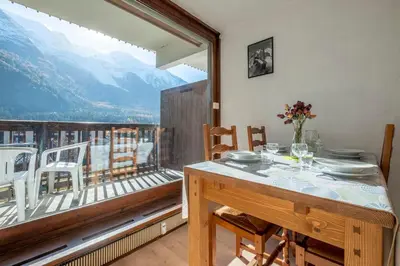 a dining room with a table and a balcony at Nice Studio With Balcony In Chamonix in Chamonix-Mont-Blanc