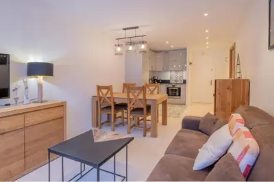 a living room and kitchen with a couch and a table at Portes du Brevent -1 bedroom apartment with magnificient Mont Blanc views in Chamonix-Mont-Blanc