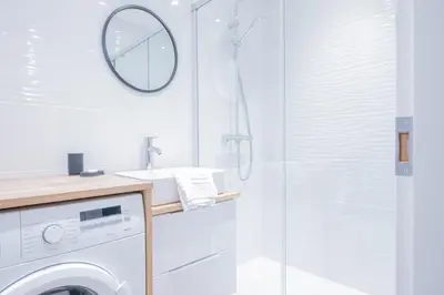 a bathroom with a washing machine and a shower at Portes du Brevent -1 bedroom apartment with magnificient Mont Blanc views in Chamonix-Mont-Blanc