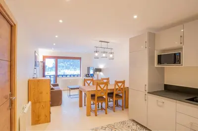 a kitchen and dining room with a table and chairs at Portes du Brevent -1 bedroom apartment with magnificient Mont Blanc views in Chamonix-Mont-Blanc