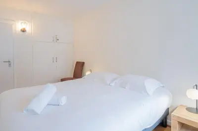 a bedroom with a white bed with white pillows at Portes du Brevent -1 bedroom apartment with magnificient Mont Blanc views in Chamonix-Mont-Blanc