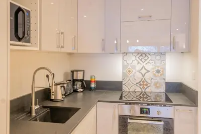 a kitchen with white cabinets and a sink at Portes du Brevent -1 bedroom apartment with magnificient Mont Blanc views in Chamonix-Mont-Blanc