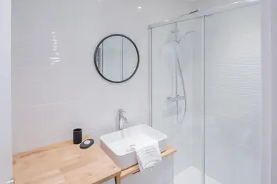 a white bathroom with a sink and a shower at Portes du Brevent -1 bedroom apartment with magnificient Mont Blanc views in Chamonix-Mont-Blanc