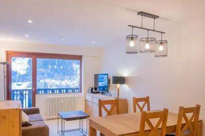 a kitchen and dining room with a table and chairs at Portes du Brevent -1 bedroom apartment with magnificient Mont Blanc views in Chamonix-Mont-Blanc