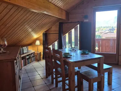 a dining room with a table and chairs and a window at Confortable T2 proche télécabine Grand Massif - FR-1-624-41 in Samoëns
