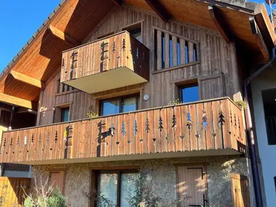 a house with a wooden deck on the side of it at Confortable T2 proche télécabine Grand Massif - FR-1-624-41 in Samoëns