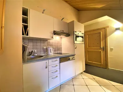 a small kitchen with white cabinets and a sink at Confortable T2 proche télécabine Grand Massif - FR-1-624-41 in Samoëns