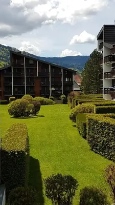 a green yard with a building in the background at Samoëns - Studio Les Espaces in Samoëns