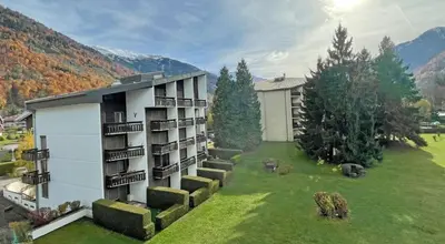 a building with a grassy yard next to a building at Samoëns - Studio Les Espaces in Samoëns
